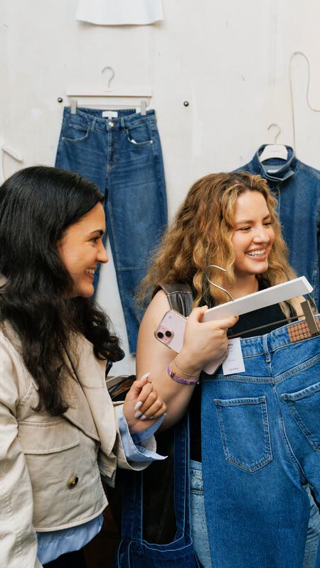 Zwei Gäste begutachten Jeans bei einem Brand Event